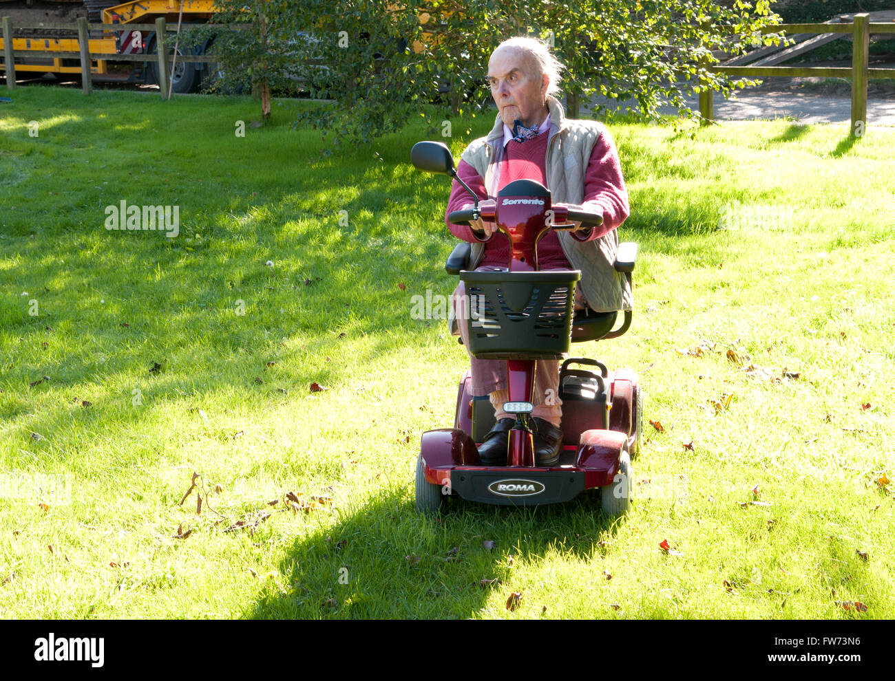 Un homme âgé à l'aide d'un scooter de mobilité Banque D'Images