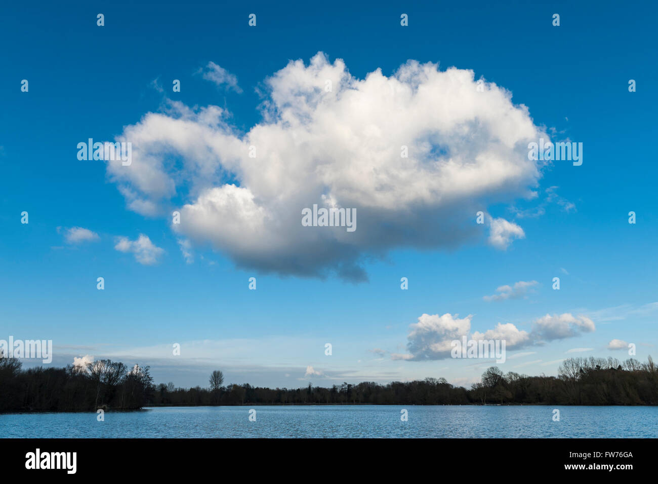Un nuage moelleux passe au dessus du lac sur une après-midi de printemps à Rickmansworth Aquadrome. Banque D'Images
