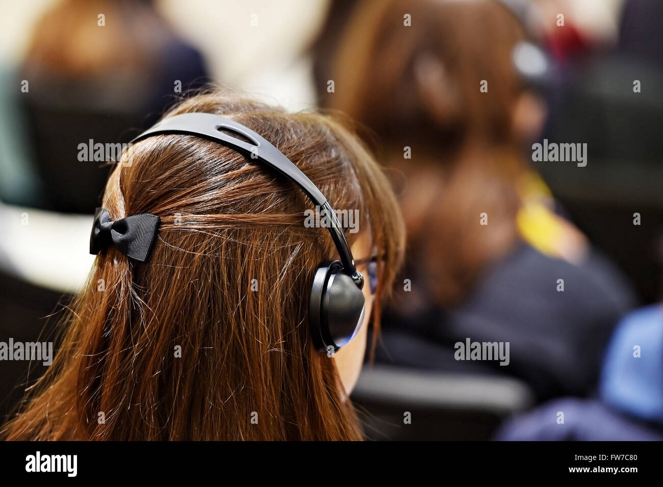 À l'aide de personnes méconnaissables dans l'oreille d'écouteurs pour la traduction pendant l'événement Banque D'Images