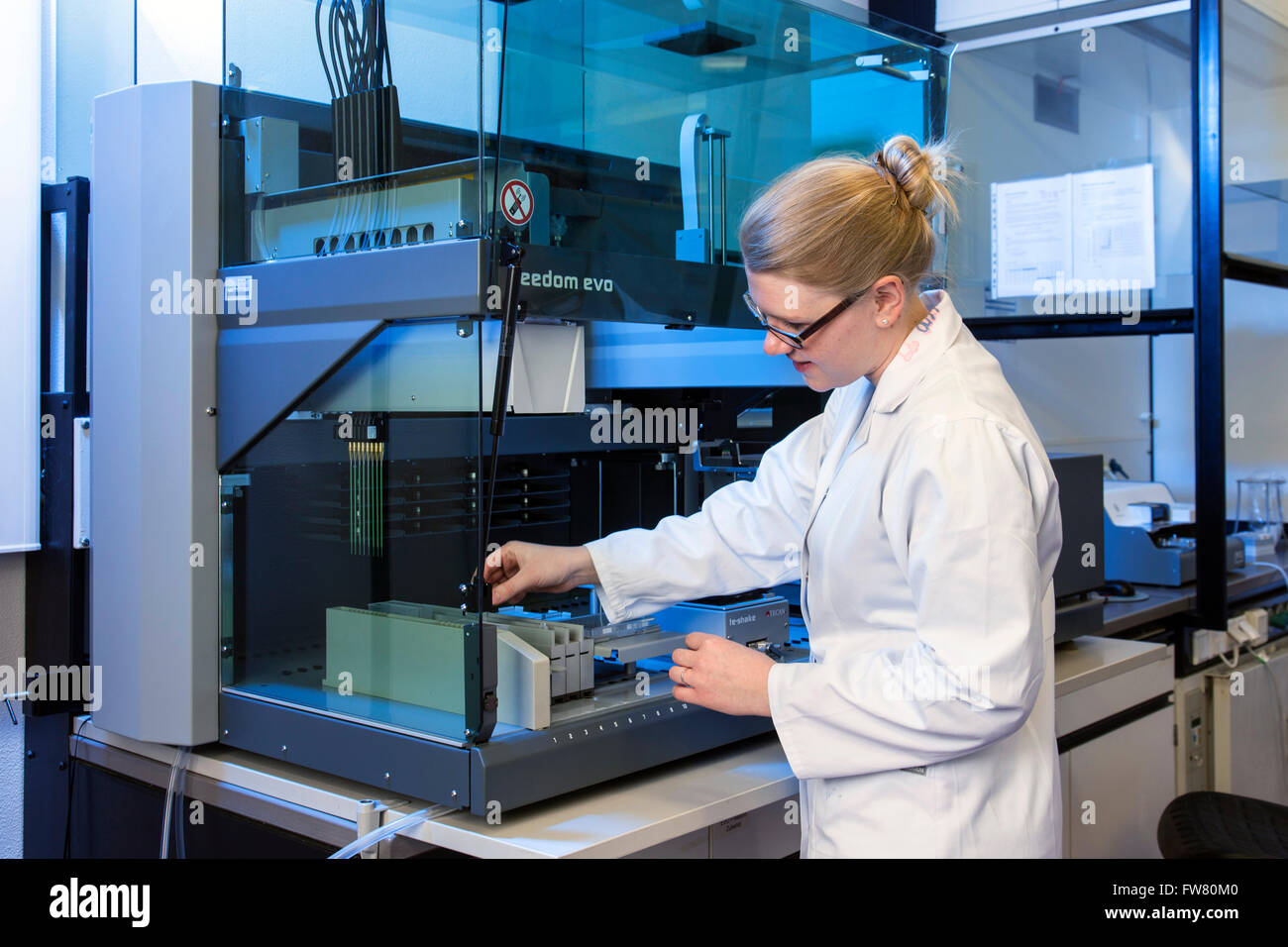 Chercheur scientifique à un robot de pipetage Banque D'Images