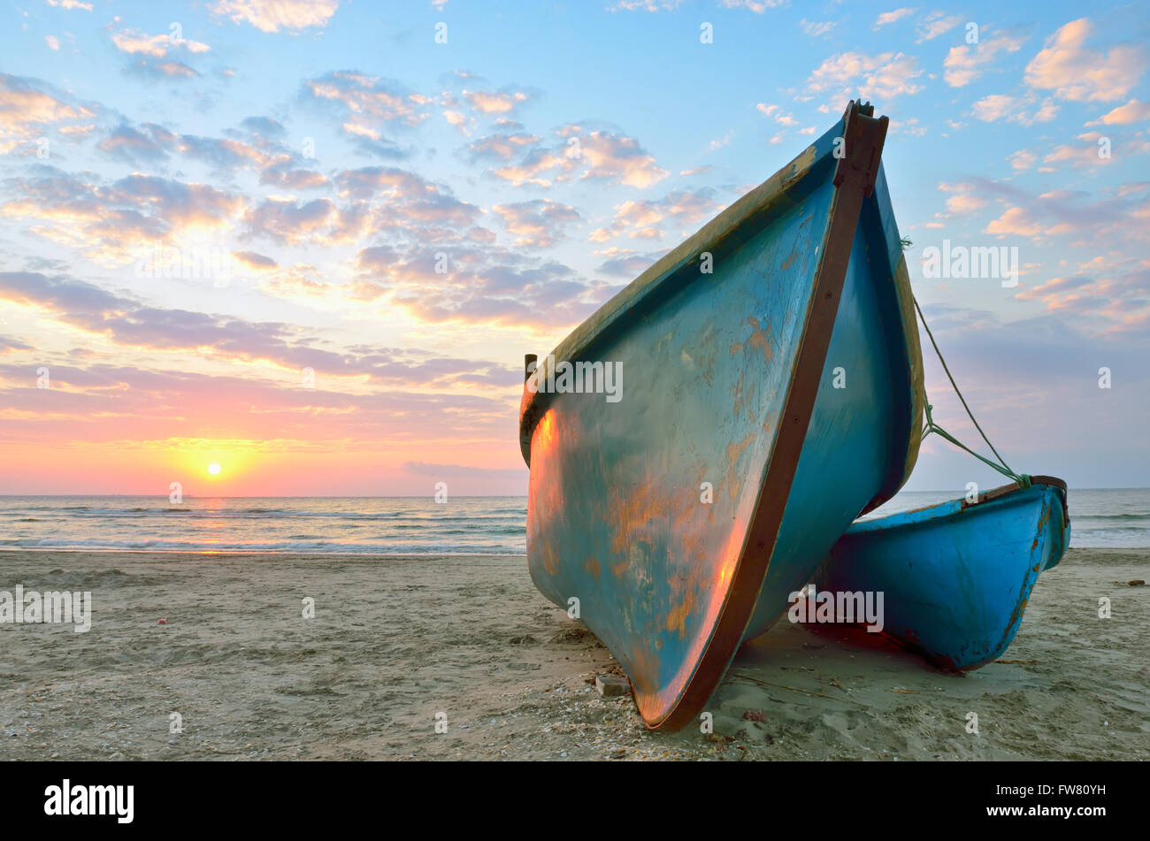 Beau lever de soleil sur l'un des deux bateaux de pêche en bois Banque D'Images