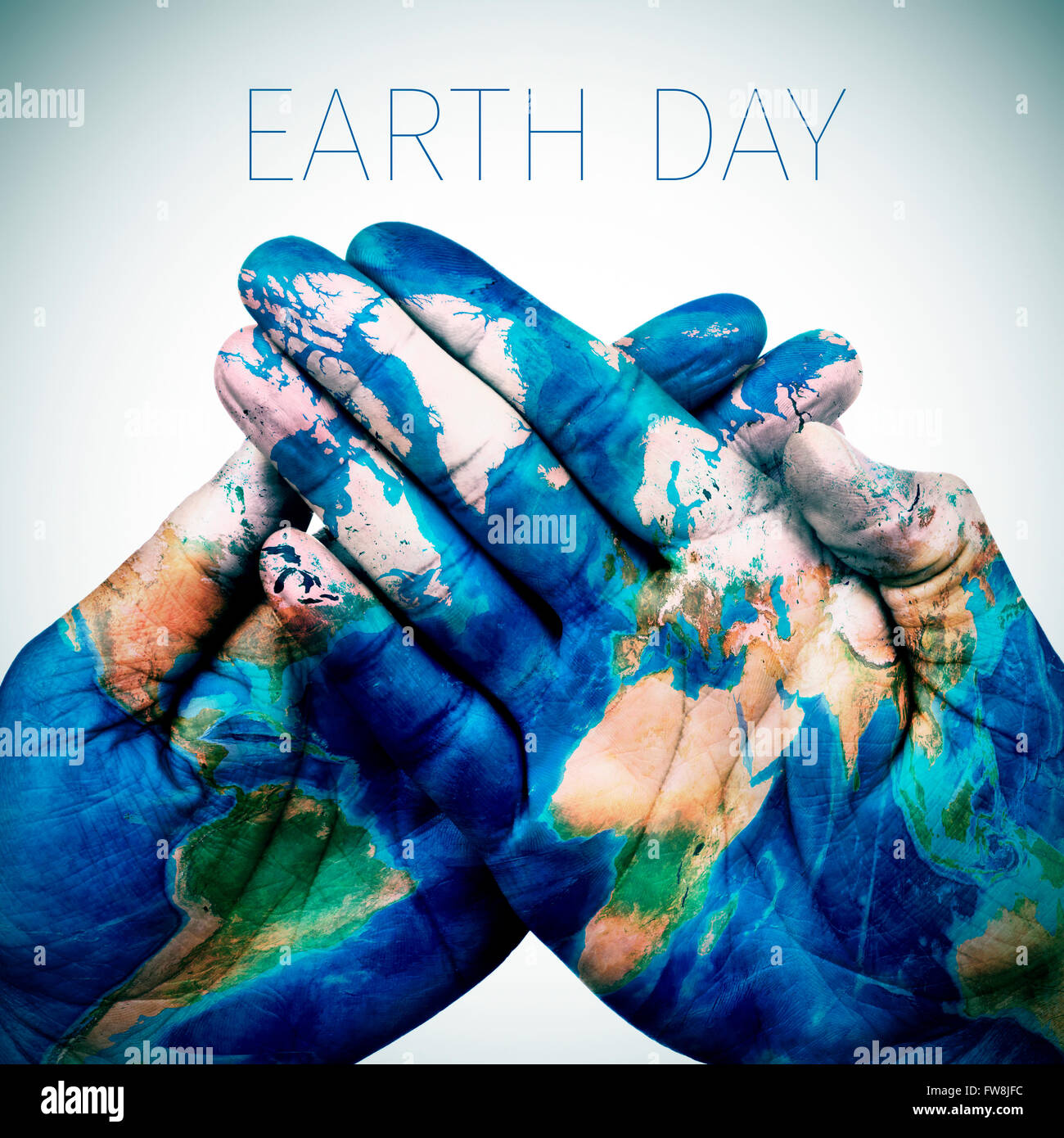 Le texte le jour de la terre et les mains d'un jeune homme mis ensemble, avec une carte du monde (fourni par la NASA) Banque D'Images