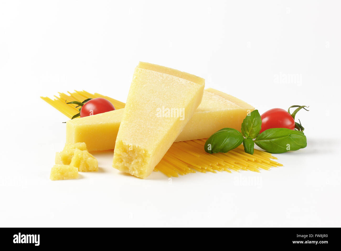 Deux cales de fromage parmesan frais, des légumes et des spaghettis sur fond blanc Banque D'Images