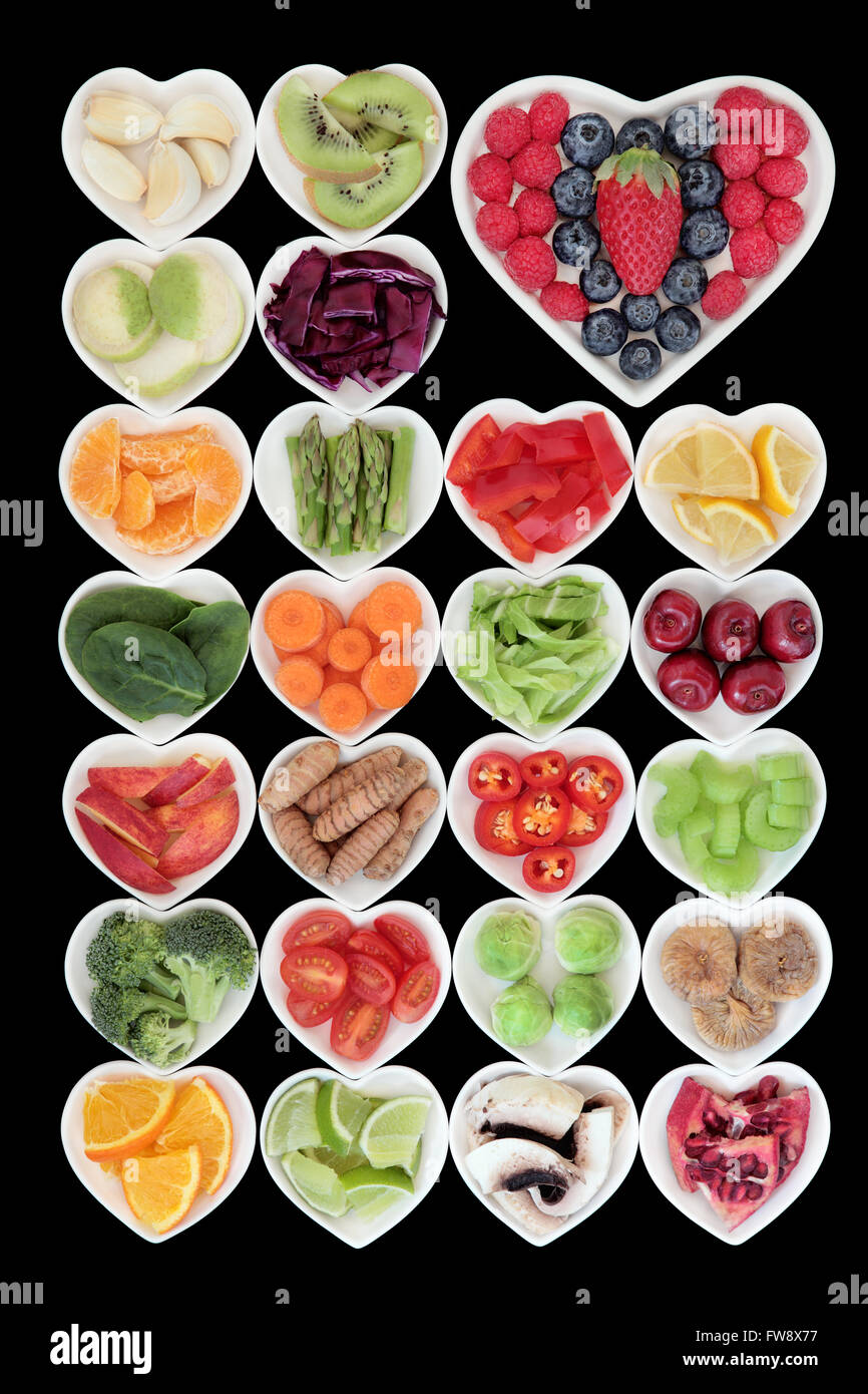 Super aliments sains sélection de légumes et de fruits en porcelaine en forme de coeur en haut des plats antioxydants et vitamines. Banque D'Images