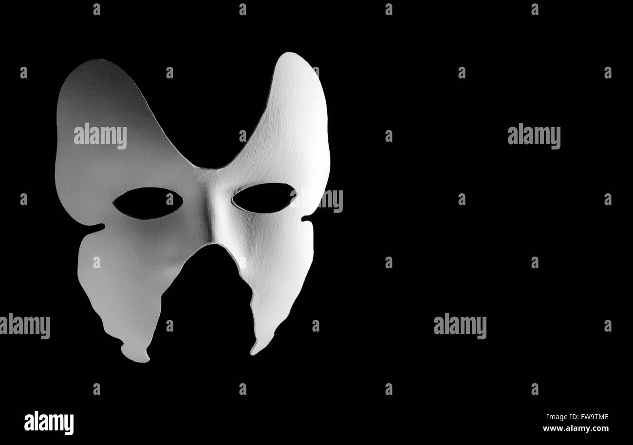 Masque de carnaval italien blanc sur fond noir avec de l'espace libre pour le texte. Banque D'Images