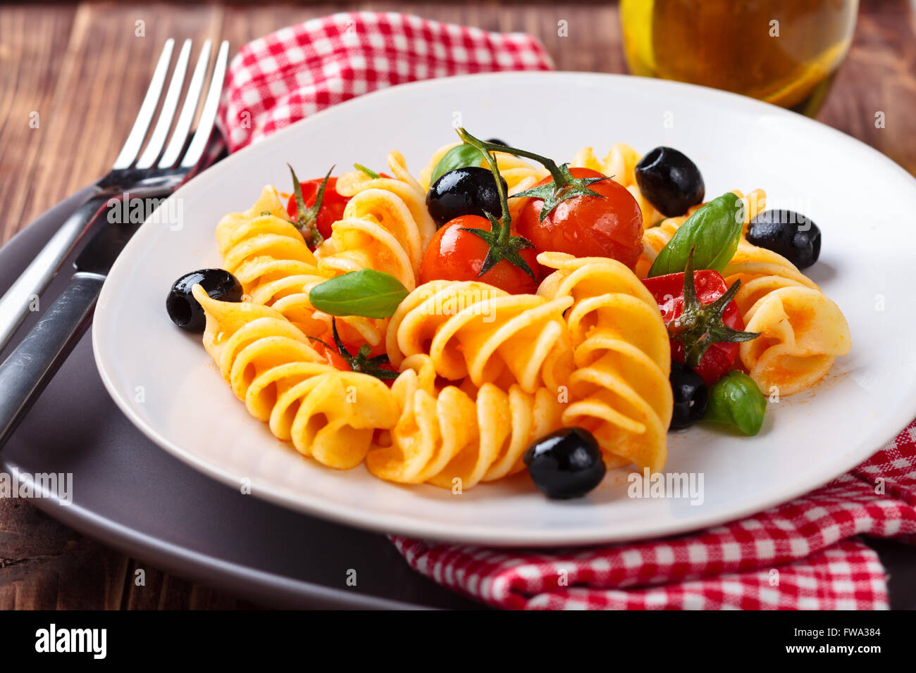 Les pâtes italiennes avec tomates cerises, olives noires et de basilic. Banque D'Images