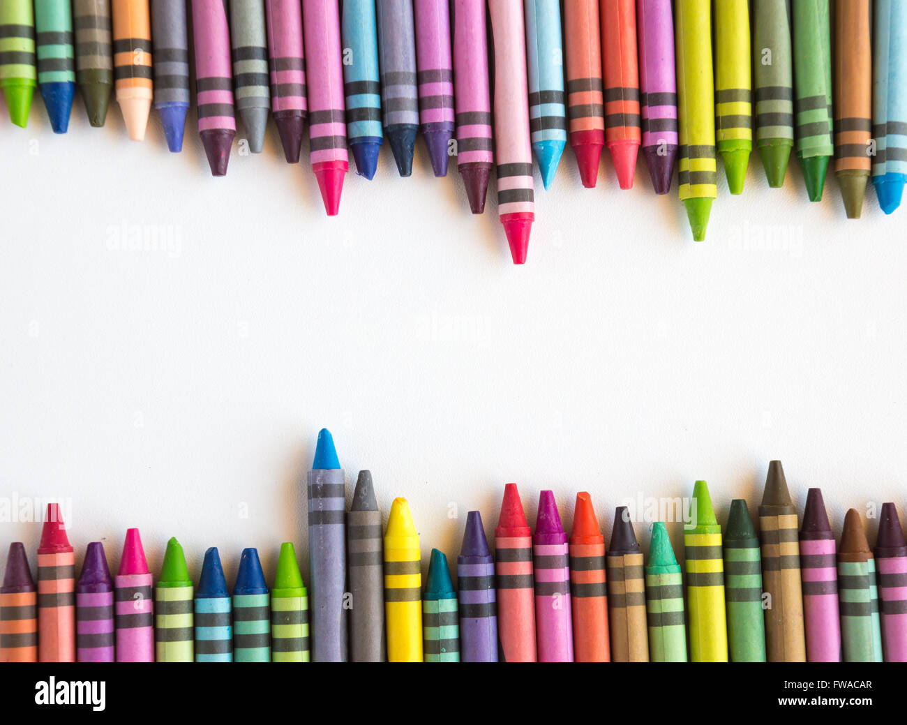 Crayons et pastels alignés dans rainbow isolé sur fond blanc Banque D'Images