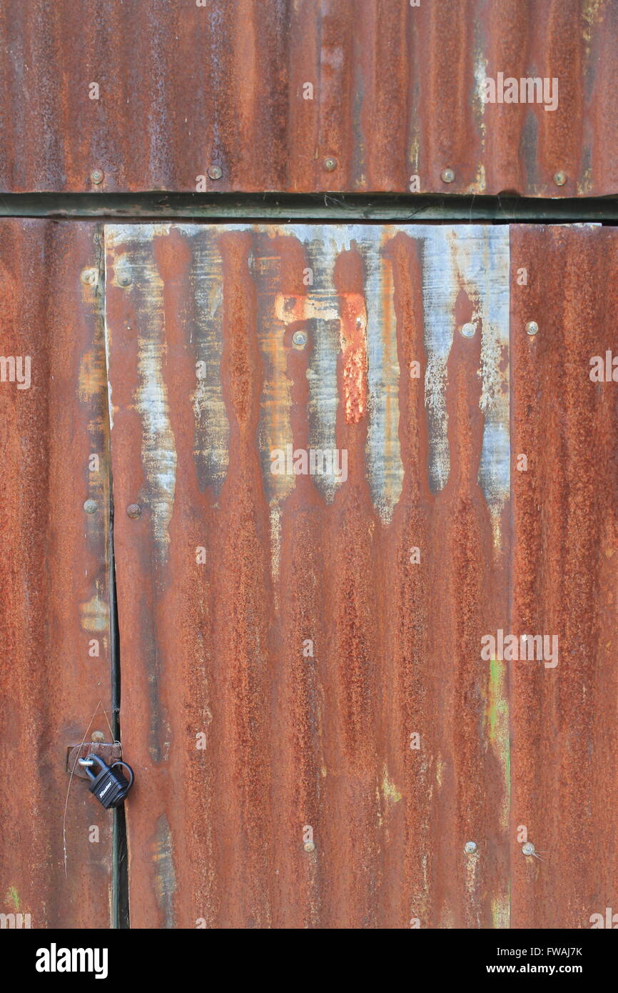 Rusty, feuilles de métal ondulé et d'un cadenas de porte de protection Banque D'Images