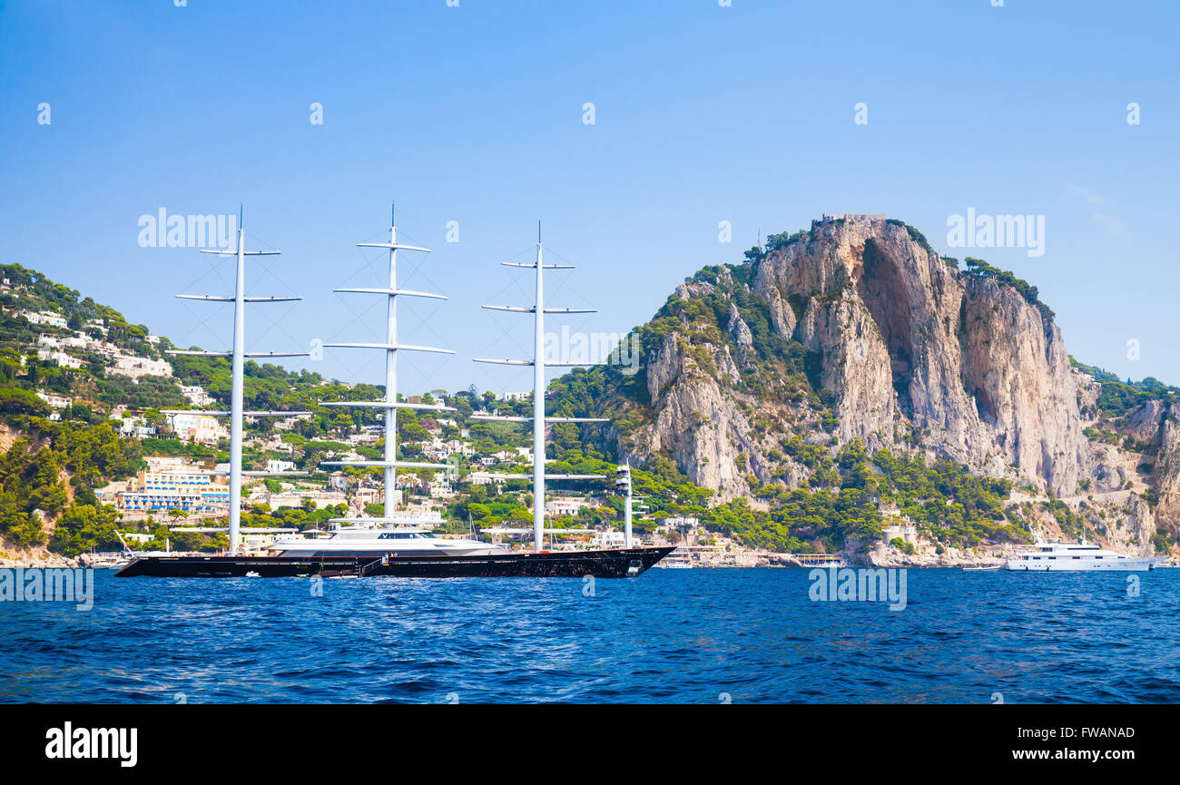 Capri, Italie - 14 août 2015 : grand plaisir yacht à s'approche de l'île de Capri avec plage de Marina Piccola sur un arrière-plan Banque D'Images