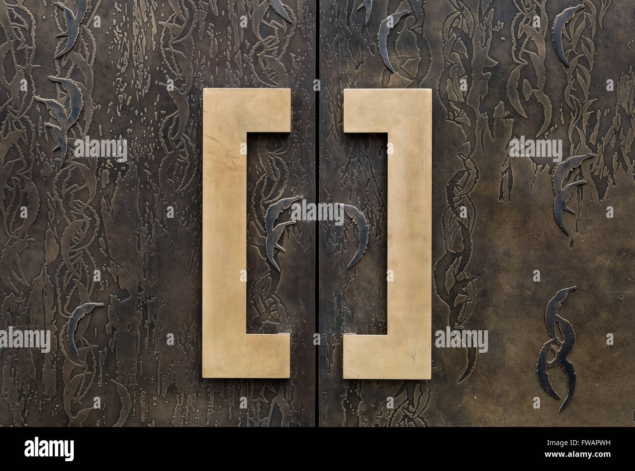 Doorhandles en laiton sur une porte de bronze à motifs sur un appartement à Londres Banque D'Images