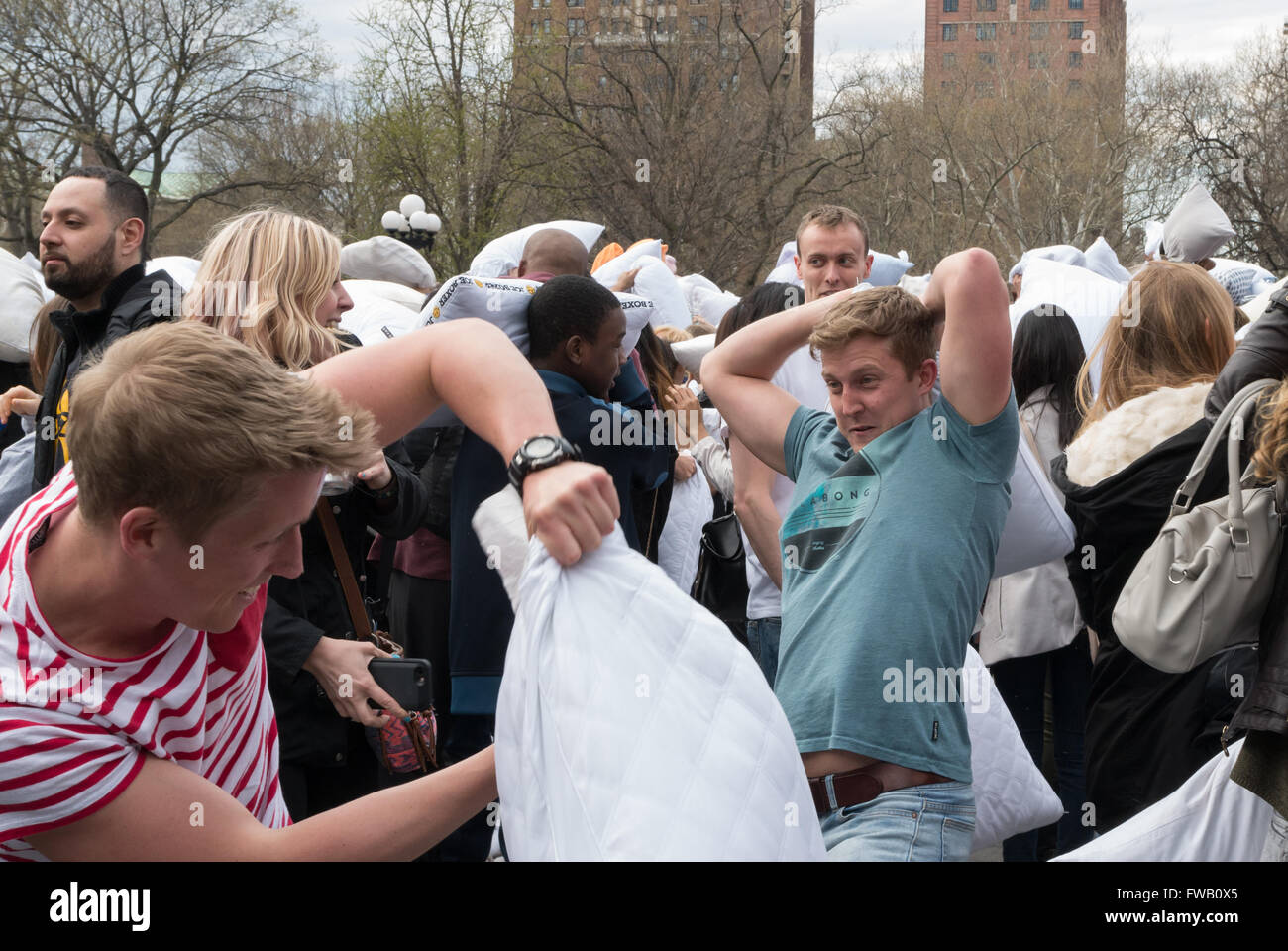 Les jeunes hommes / adolescents ayant un oreiller lutte à Washington Square Park dans les mondes plus grand pillow fight flash mob, New York Banque D'Images