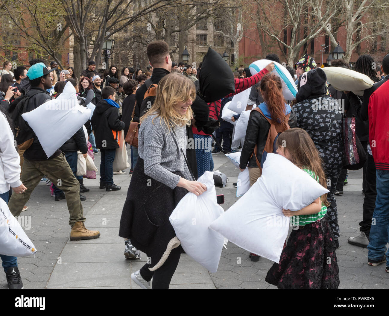 Woman having a pillow fight avec petite fille à Washington Square Park dans la plus grande guerre d'oreillers flash mob, New York Banque D'Images