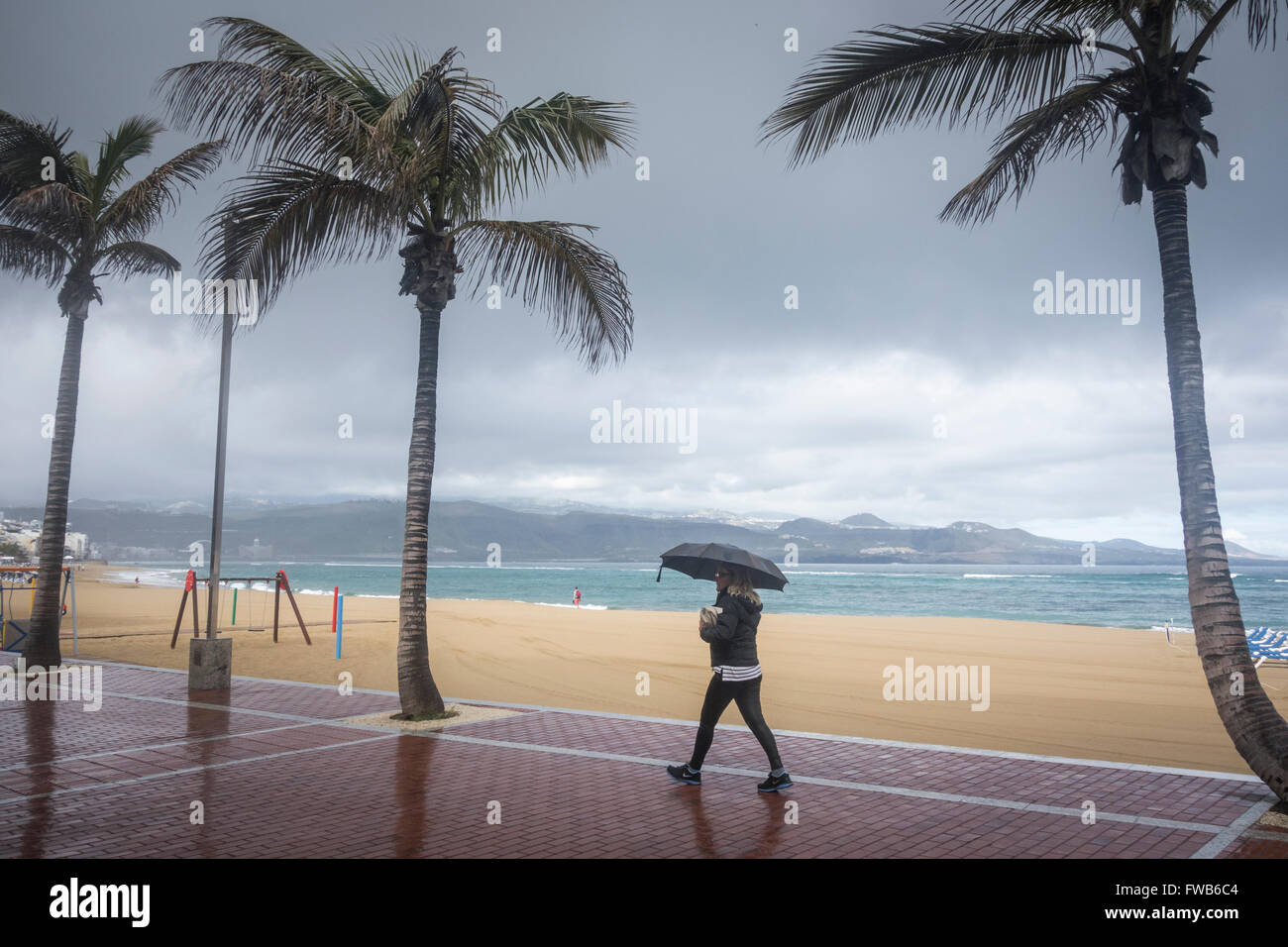 Las Palmas, Gran Canaria, Îles Canaries, Espagne, 3e avril 2016. Météo : avec une grande partie de l'UK devraient avoir chaud soleil le dimanche de la presse britannique et dire "plus chaud que l'Espagne...', c'est un dimanche matin pluvieux à Las Palmas de Gran Canaria comme une bande de pluie balaie la plage de la ville. Credit : Alan Dawson News/Alamy Live News Banque D'Images