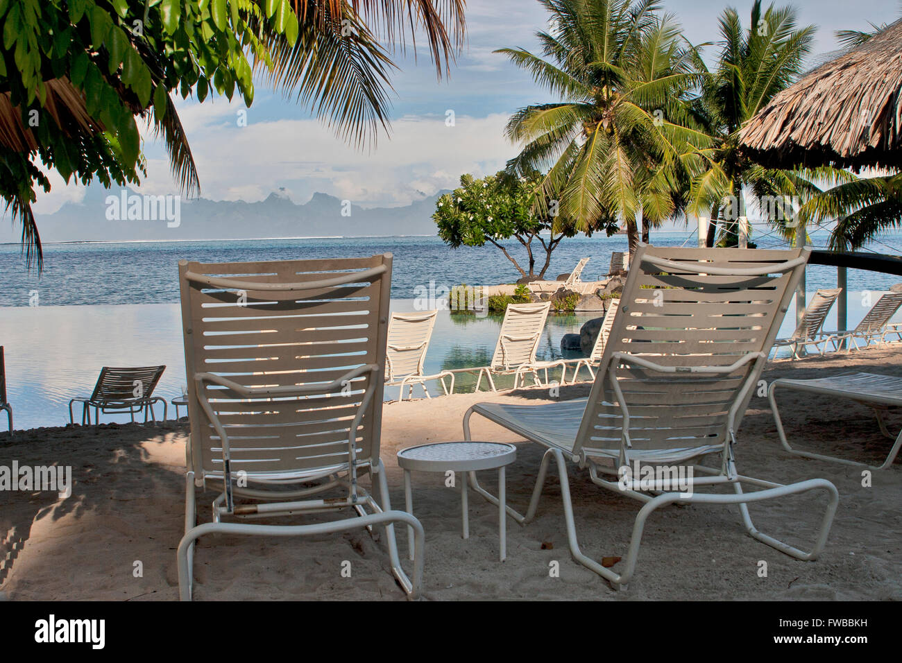 Tahiti, Polynésie Française, chaises de plage sur une plage à Papeete,  Thaiti avec les montagnes de Moorea en arrière-plan Photo Stock - Alamy