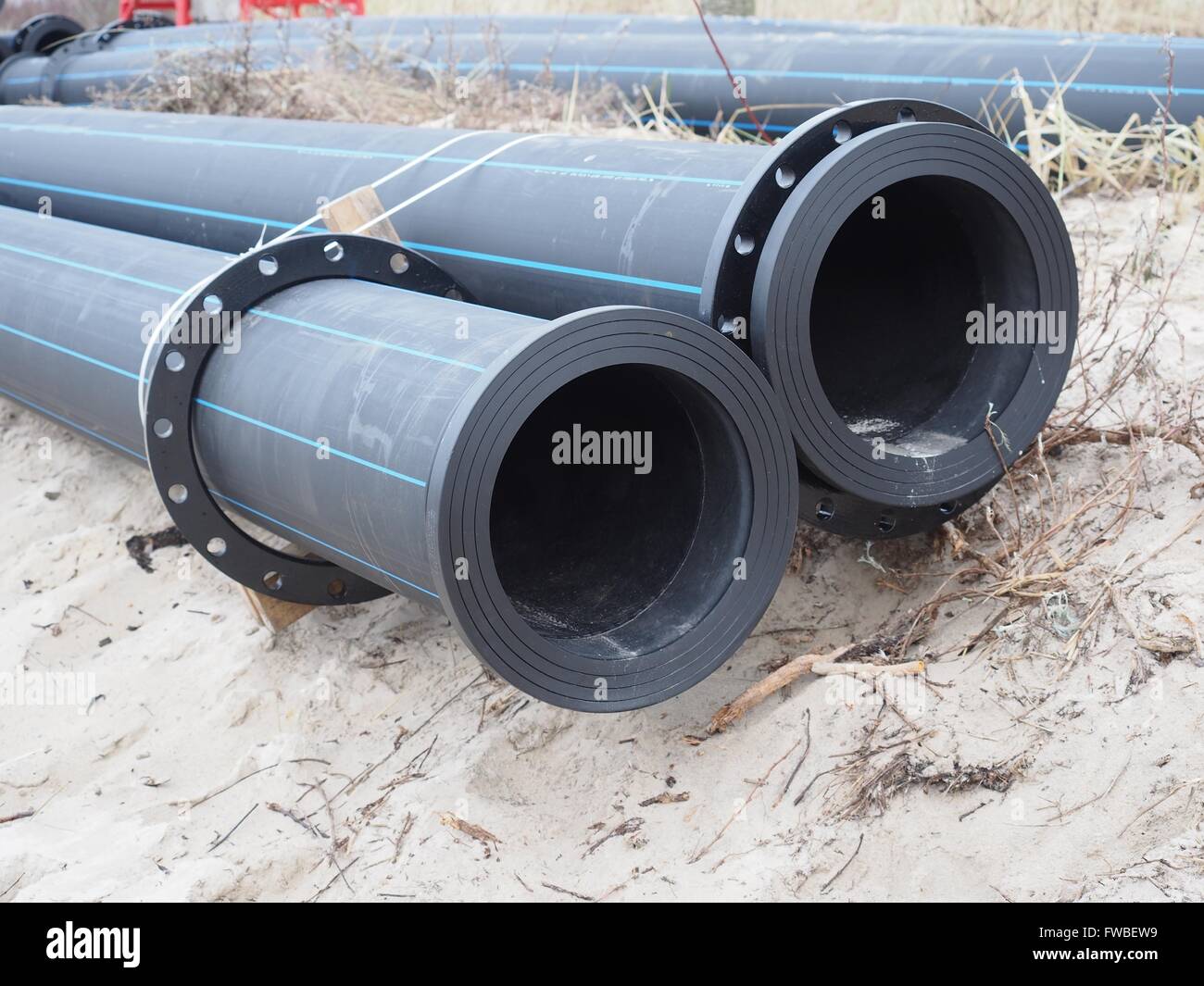 Tuyaux en plastique sur fond de sable Banque D'Images