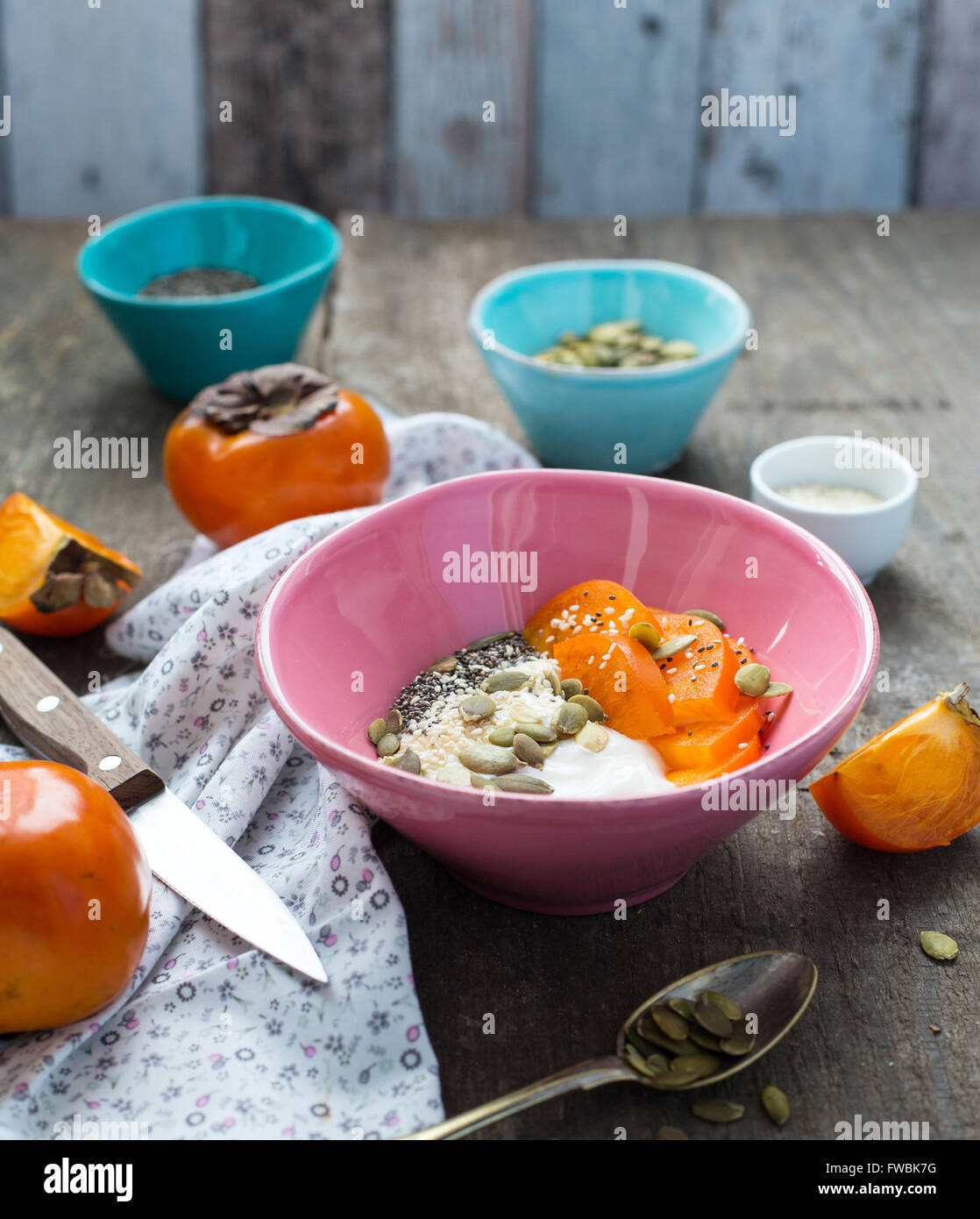 Bol de petit-déjeuner avec du yogourt garni de graines superfood et persimmon Banque D'Images