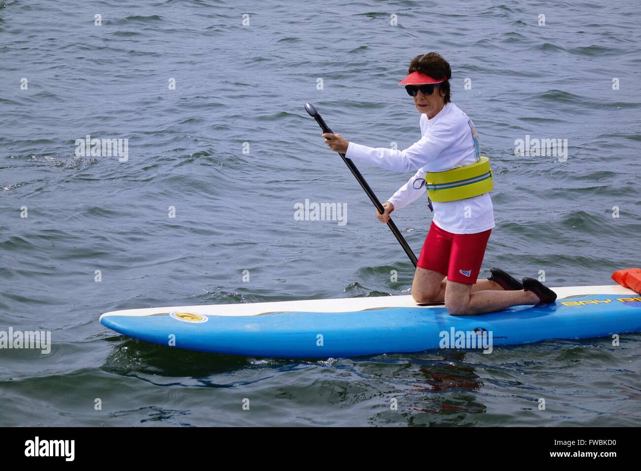 Paddleboarder portant sur les genoux de flottaison sur taille Banque D'Images