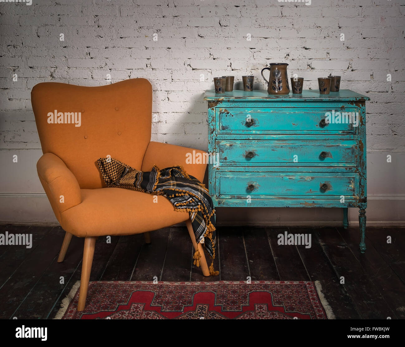 Composition du fauteuil bleu orange vintage, du cabinet et des foulard en studio Banque D'Images