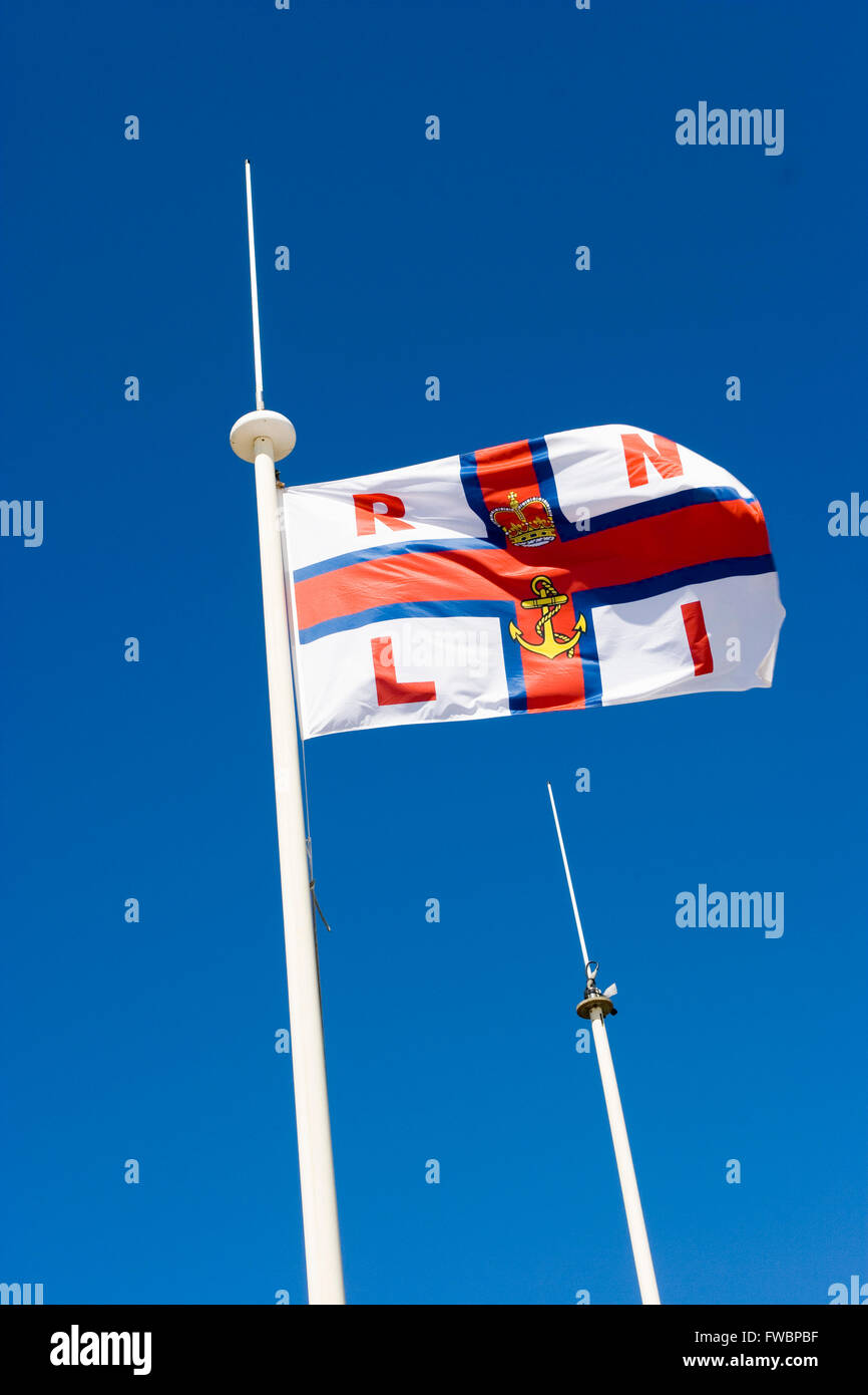 Un ou de la RNLI Royal National Lifeboat Institution drapeau à un jeu sur un jour clair lumineux. Banque D'Images