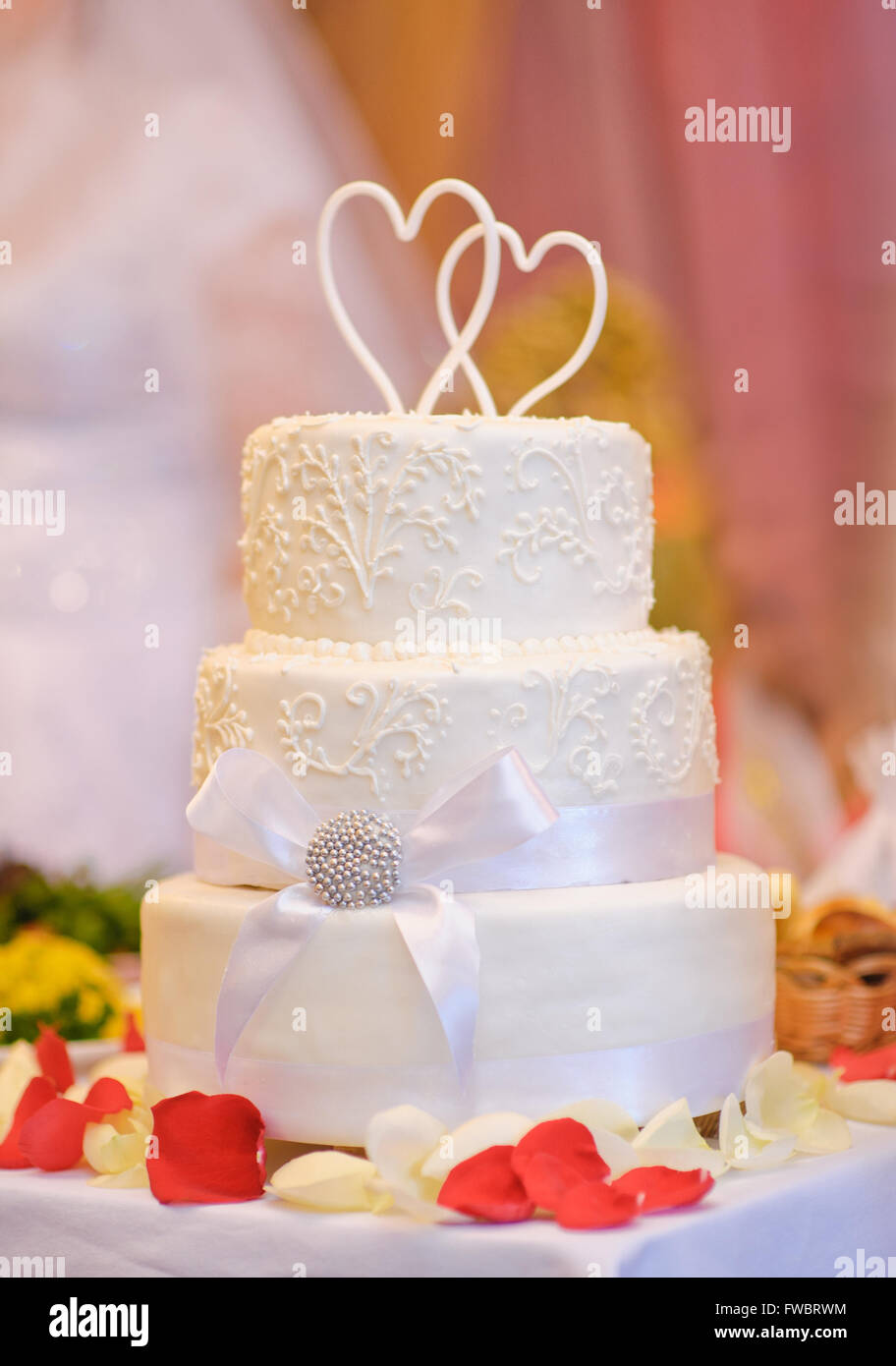 Blanc multi-niveaux gâteau de mariage avec deux cœurs au-dessus Banque D'Images