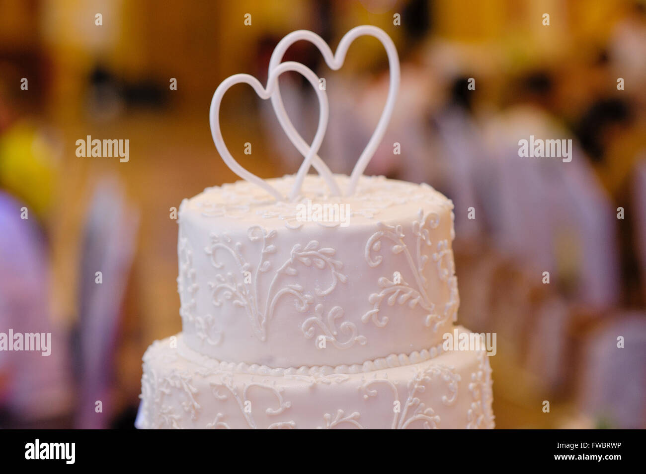 Blanc multi-niveaux gâteau de mariage avec deux cœurs au-dessus Banque D'Images