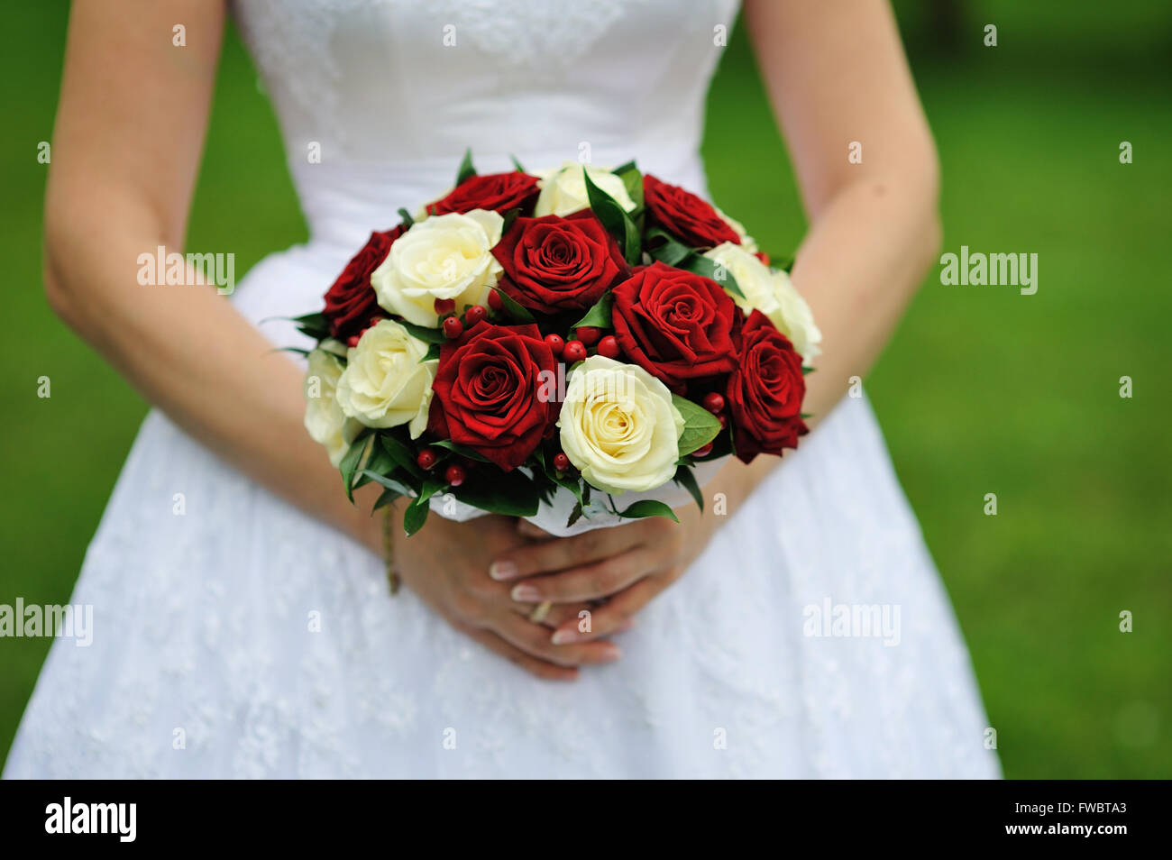 Bride holding bouquet de fleur de mariage de roses rouges et blanches Banque D'Images