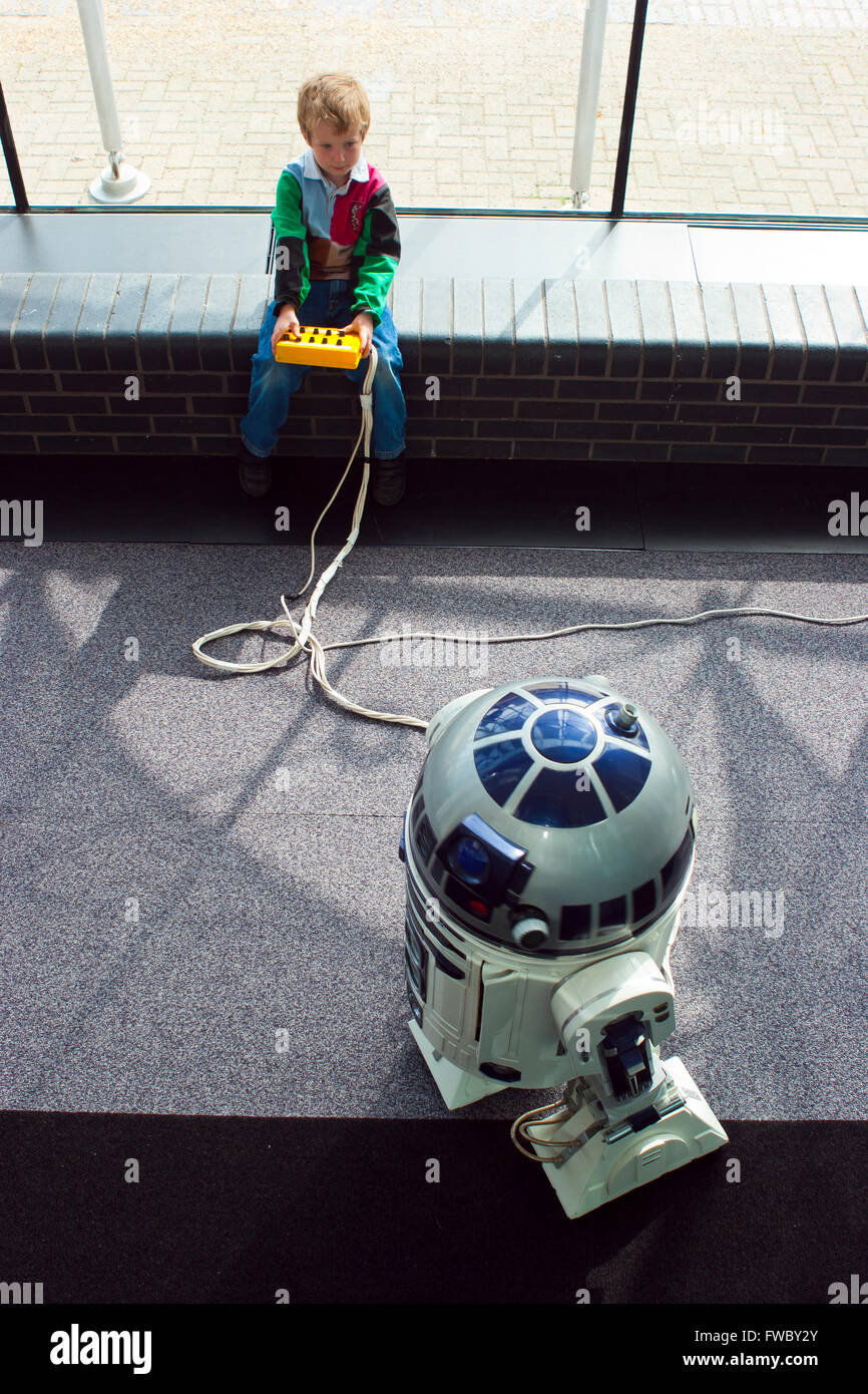 Les petits enfants palying à ascience centre avec un modèle de robot R2D2 le personnage de la série de films Star Wars. Banque D'Images