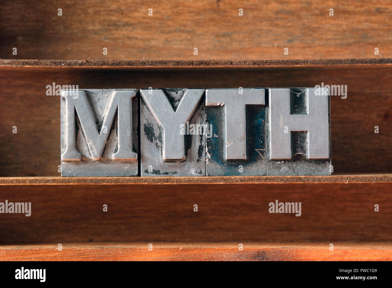 Mot mythe fabriqué à partir de type typographique métallique sur plateau en bois Banque D'Images
