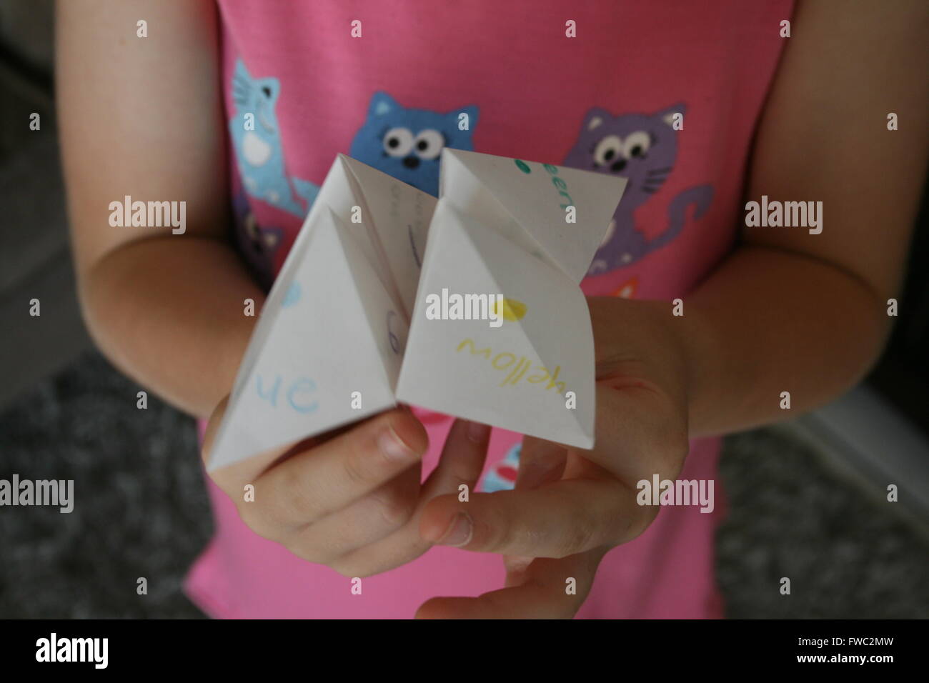 Enfant tenant l'origami fortune teller Banque D'Images