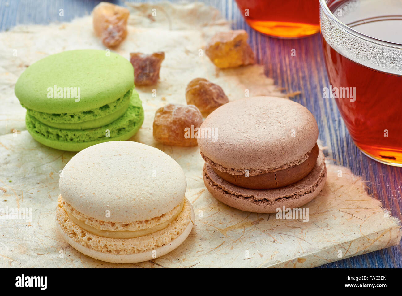 Tasse en verre de thé noir et de macarons colorés Banque D'Images