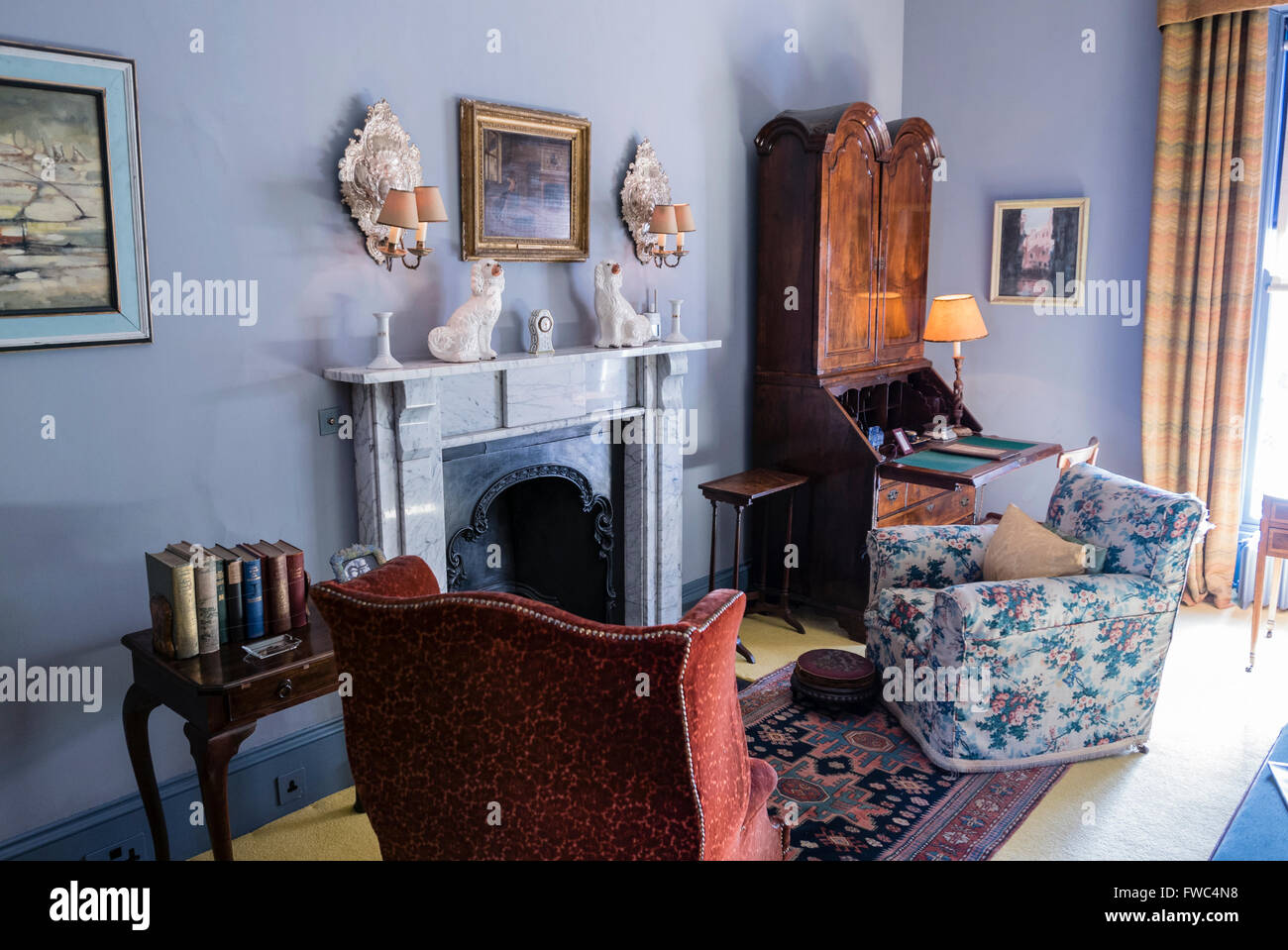 Chaises disposées autour d'une cheminée dans le salon d'une maison à l'ancienne Banque D'Images