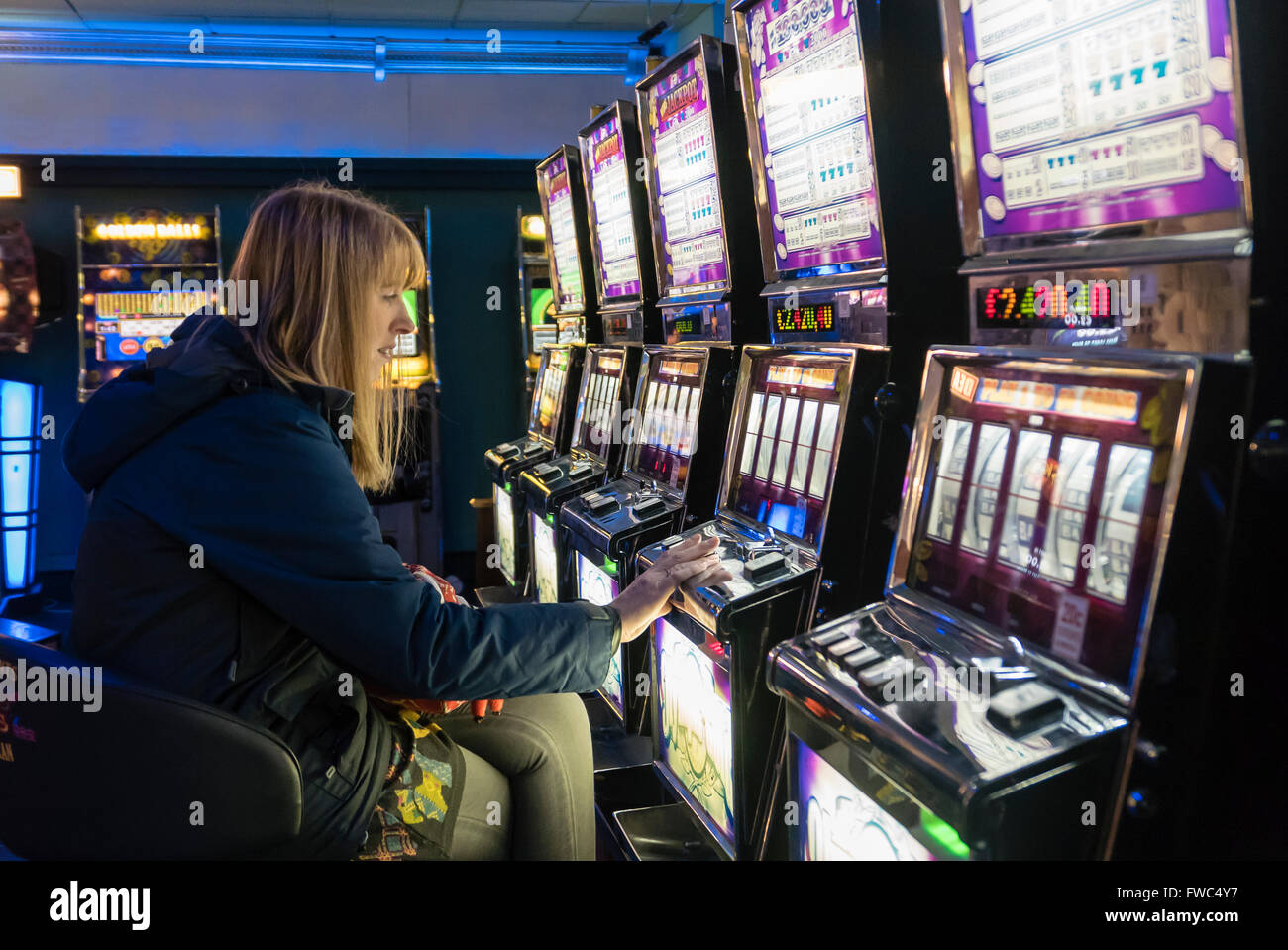 Femme seule jouant un jackpot machine dans un casino. Banque D'Images