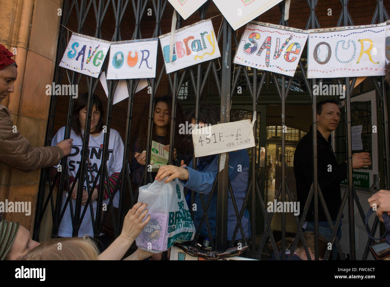 Les militants protestent contre la fermeture de la bibliothèque Carnegie de Lambeth de l'approvisionnement alimentaire passe par l'entrée à Herne Hill, dans le sud de Londres le 2 avril 2016. La colère de la communauté locale dans le département du sud ont occupé leurs ressource importante pour l'apprentissage et de rencontre pour la fin de semaine. Après une longue campagne menée par les sections locales, Lambeth sont allés de l'avant et fermé les portes de la bibliothèque pour la dernière fois parce qu'ils disent, les coupes dans leur budget des millions moyenne doit être enregistré. Une salle de sport va remplacer la bibliothèque de travail et alors que certains des 20 000 livres sur des étagères resteront, pas les bibliothécaires seront prés Banque D'Images