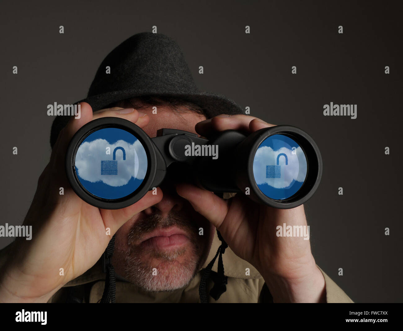 Photo d'un homme en trench-coat et chapeau binoculars avec cloud symboles dans les lentilles. Banque D'Images