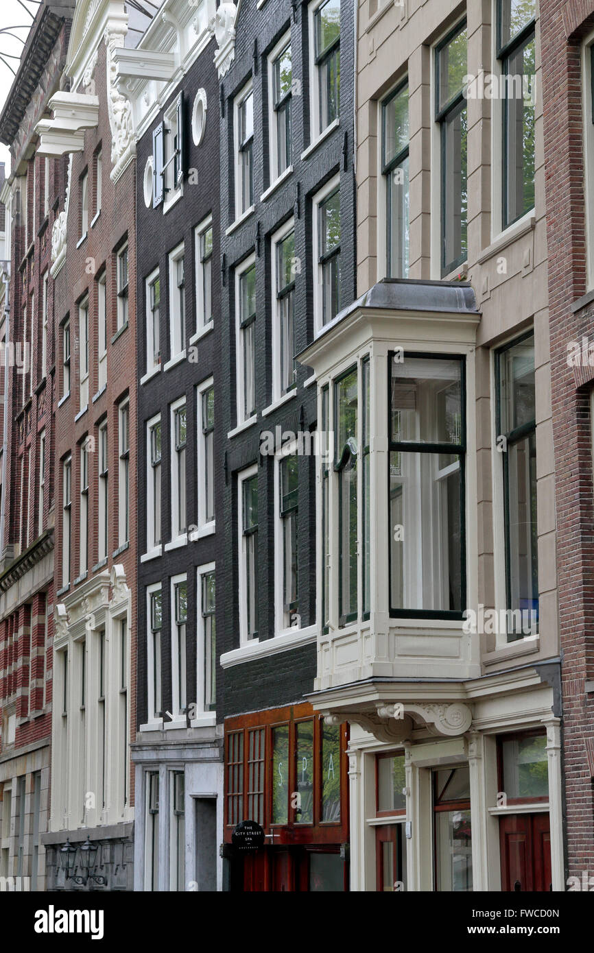 Vue en angle du canal de nombreuses fenêtres donnant sur des propriétés Néerlandais à Amsterdam, Pays-Bas. Banque D'Images