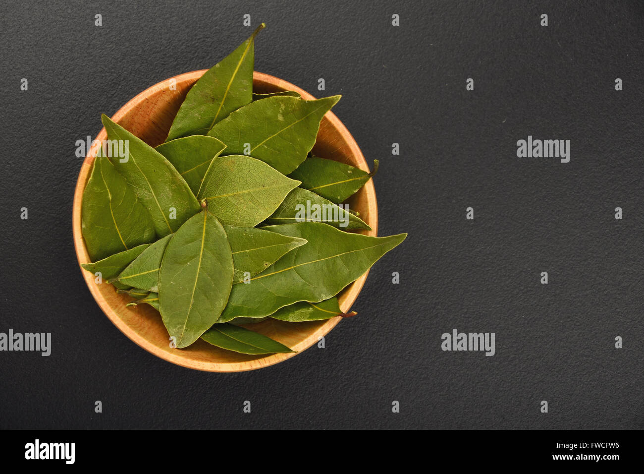 Bol en bois de bay laurel leaves on black background tableau Banque D'Images