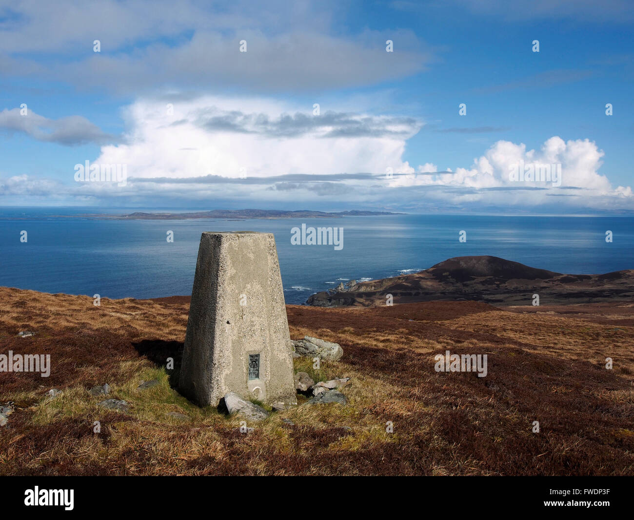 Trig point sur sommet des Sgarbh dubh, Islay, l'Écosse, avec Colonsay derrière Banque D'Images
