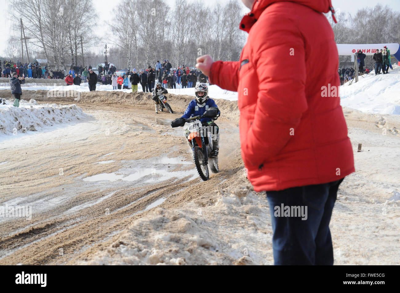 Kovrov, la Russie. 22 février 2015. Les compétitions de motocross d'hiver. Coach dynamise ses élèves lors d'une course Banque D'Images