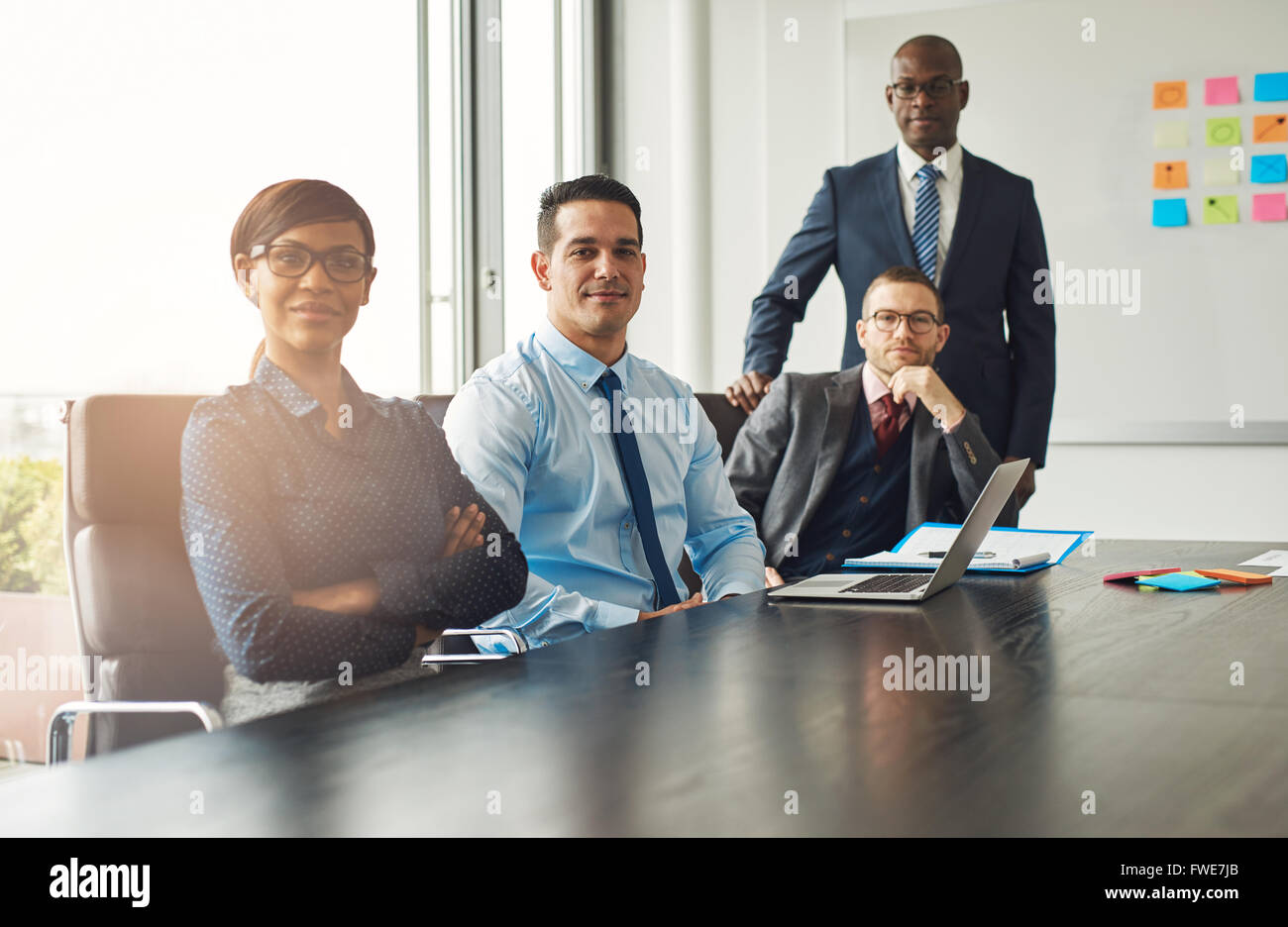 Quatre succès confiant divers partenaires ou multiraciale associates assis à une table de conférence et d'une réunion p Banque D'Images
