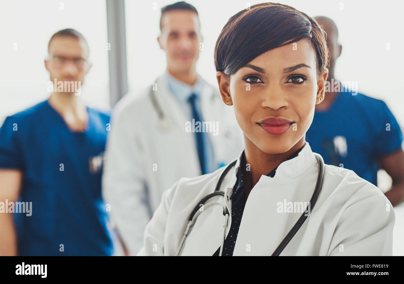 Femme médecin devant team, stéthoscope autour du cou à la confiance Banque D'Images