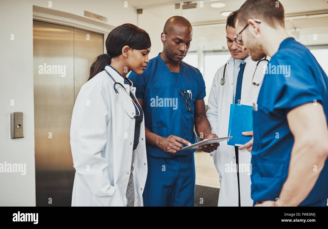 Chirurgien noir l'enseignement à l'équipe médicale à l'aide de races mixtes tablet Banque D'Images