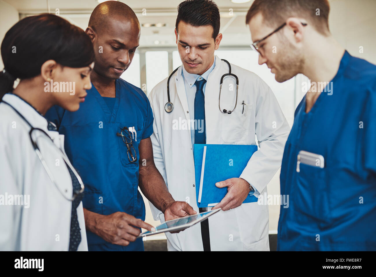 Des médecins de l'équipe multiraciale à discuter de l'hôpital, les médecins d'un patient à l'aide de tablet Banque D'Images