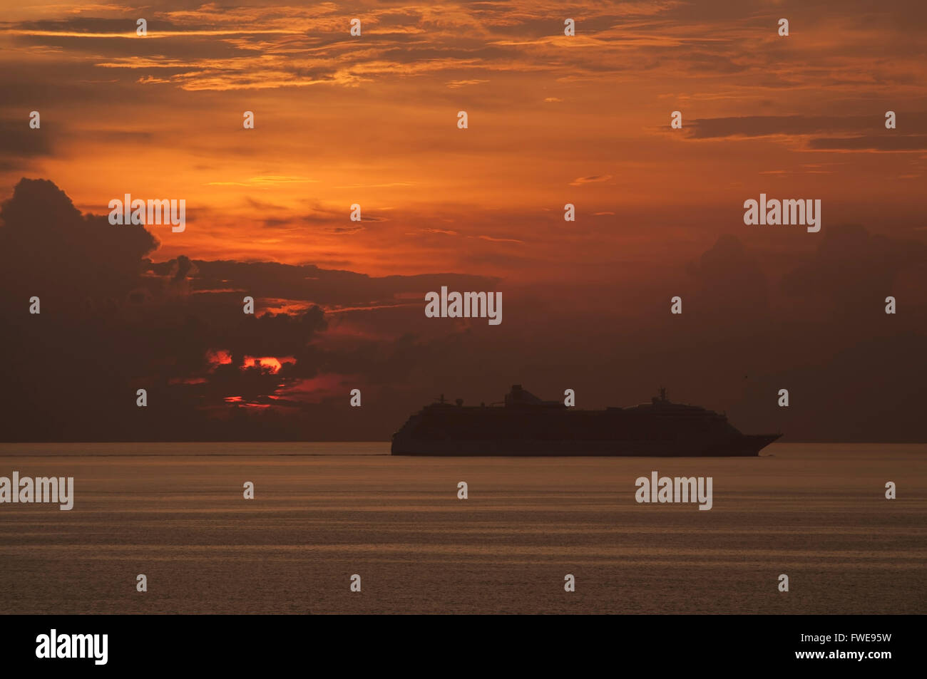 Un bateau de croisière navigue devant un soleil couchant à Aruba. Banque D'Images