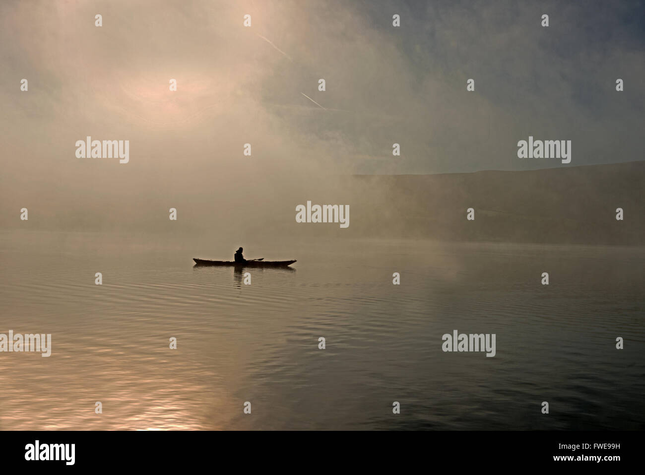 Un canoéiste sur à l'aube au cours de la brume, Le Lac Ullswater, Parc National de Lake District, Cumbria, England, UK, FR Banque D'Images