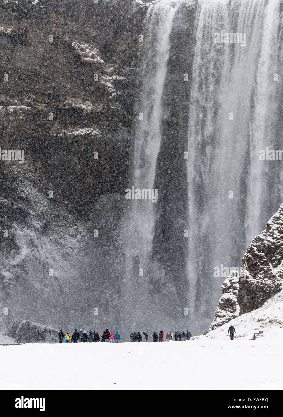 Cascade de Skogafoss en Islande sur un jour de neige de touristes autour de Banque D'Images