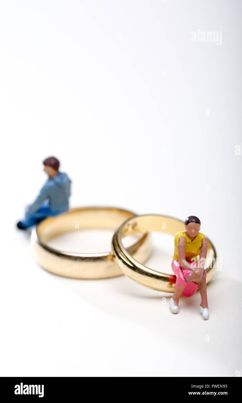 Concept de droit d'un couple assis sur les anneaux de mariage pour illustrer le divorce et la séparation Banque D'Images