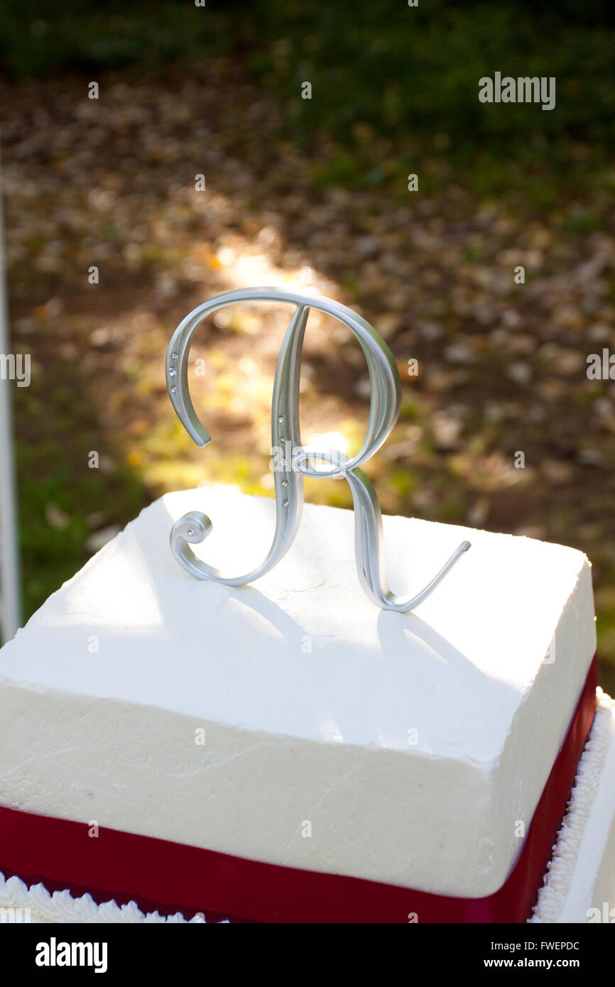 Un Carre Rouge Et Blanc Gateau De Mariage Avec Plusieurs Niveaux Et La Lettre R Sur Le Haut Se Trouve A L Exterieur Sur Une Table Jaune Pour Un Mariage Loisir Photo Stock