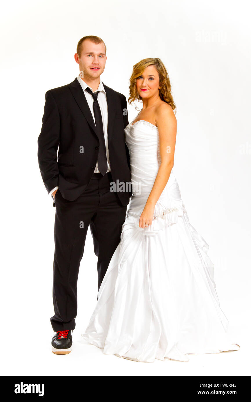 Mariée et le marié dans un studio avec un fond blanc posent pour une suite nuptiale portrait de vie dans leur habit de noces. Banque D'Images