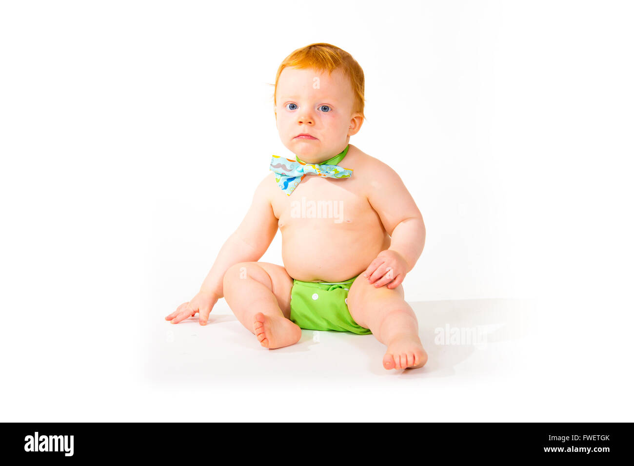 Un petit garçon âgé d'un an dans le studio avec un fond blanc. L'enfant porte un nœud papillon et une couche. Banque D'Images