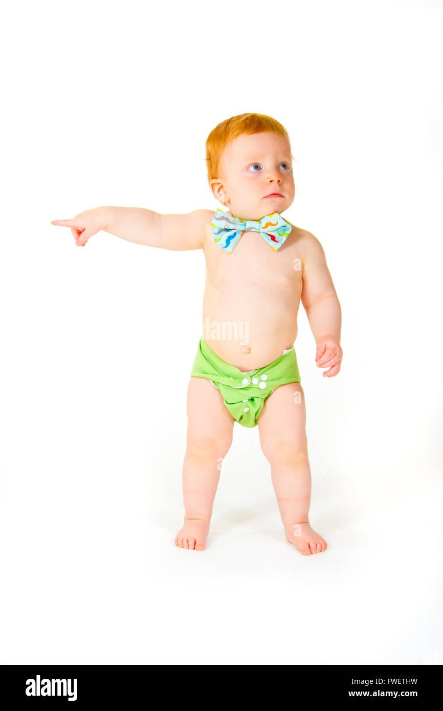 Un petit garçon âgé d'un an dans le studio avec un fond blanc. L'enfant porte un nœud papillon et une couche. Banque D'Images